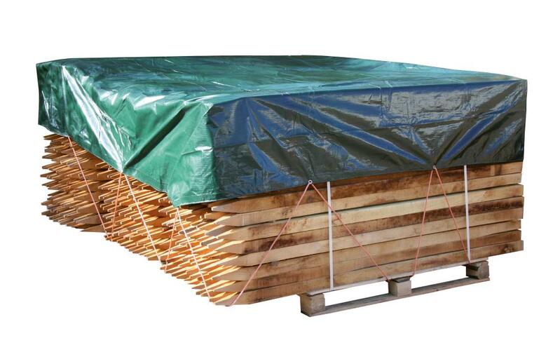 Grüne Abdeckplane über einen Stapel Holzpfähle gespannt
